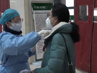 Medium a nurse measuring the body temperature for outpatients in hubei tcm hospital